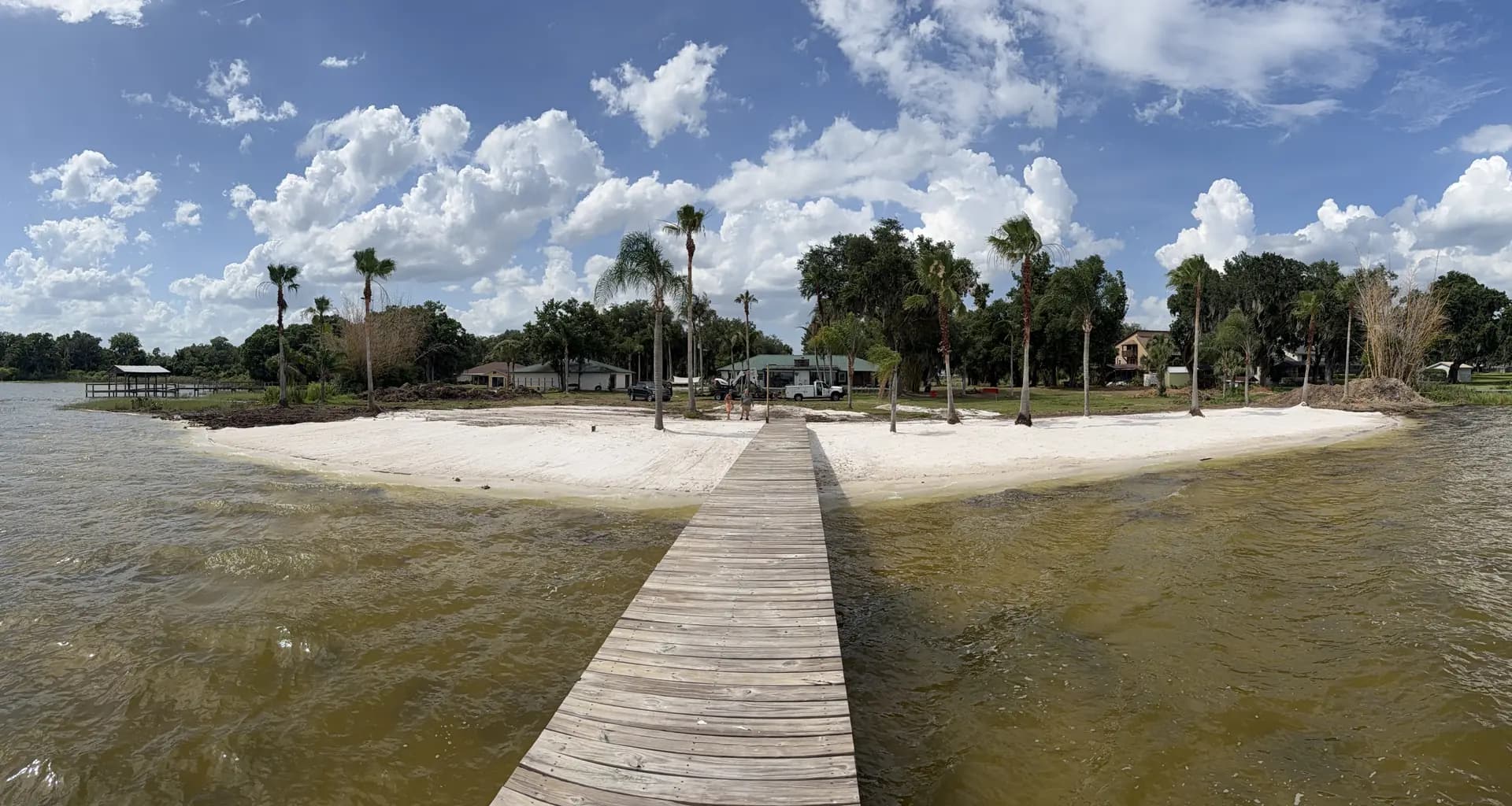Wide view of a restored Florida shoreline with a dock stretching into the water